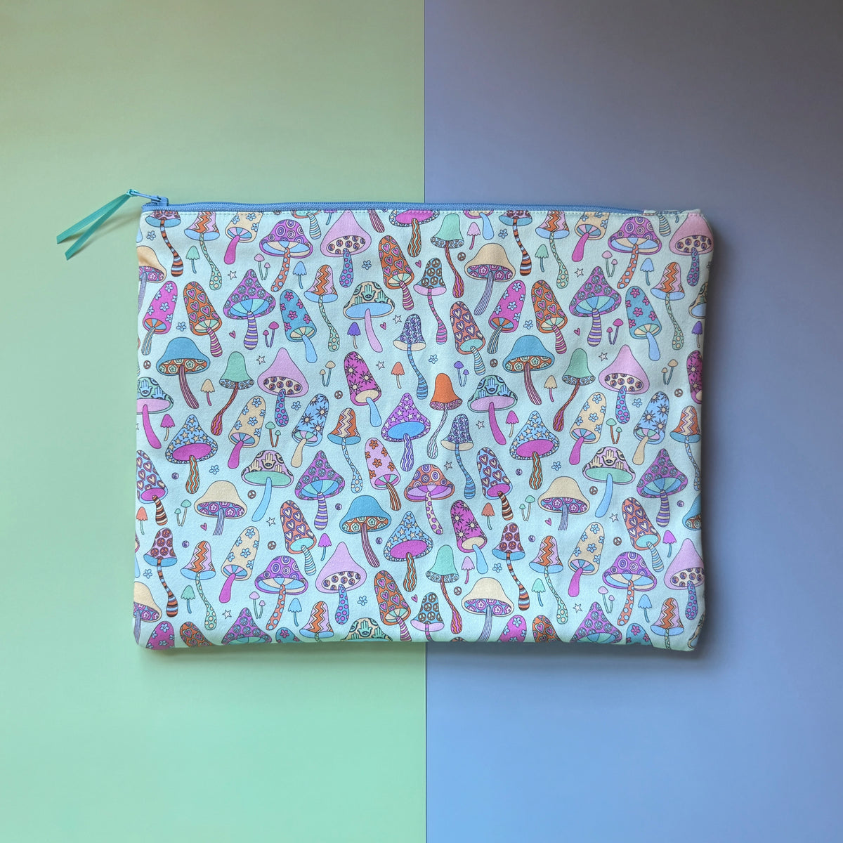 Back of the large zip pouch, showing an all-over colourful mushroom pattern and pale blue zip.
