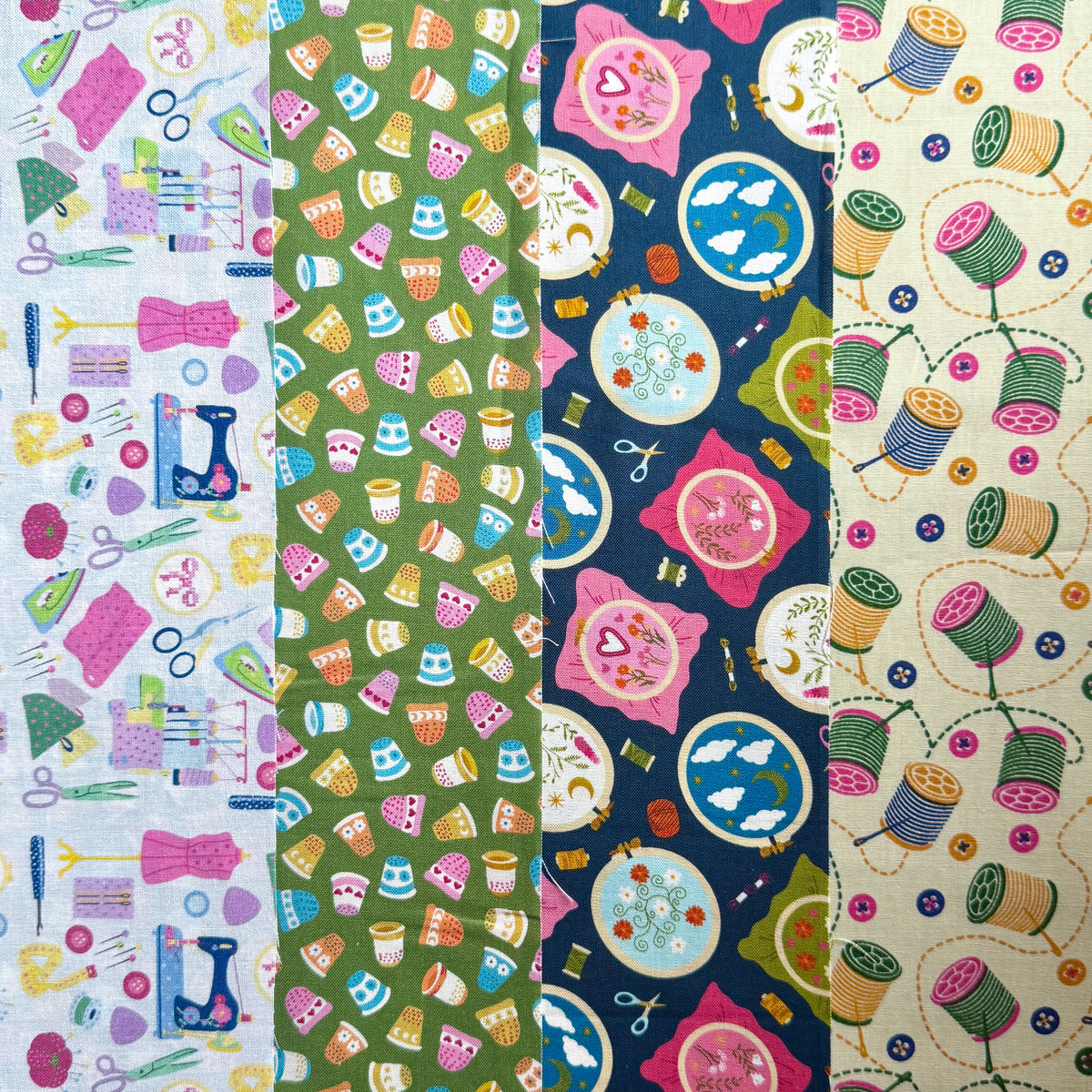Four coordinating fabric prints side by side: sewing tools on light blue background, thimbles on green, embroidery hoops on navy and thread spools on cream.