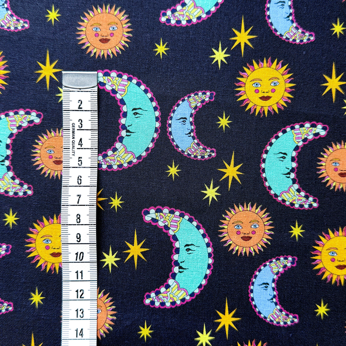Sun and moon fabric beside a centimetre tape measure to show the scale of the celestial pattern.