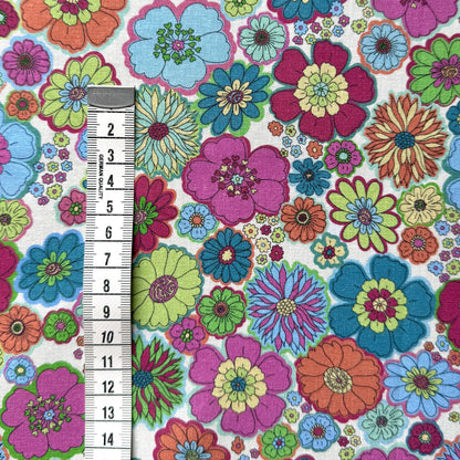 Colourful 60s floral fabric beside a centimetre tape measure to show the scale of the flower pattern.
