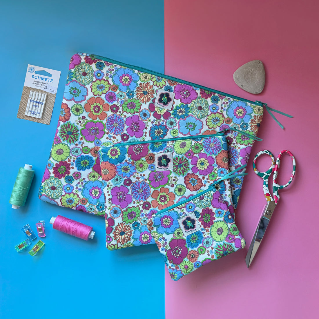 Three matching retro floral zip pouches arranged with scissors, thread and sewing accessories.