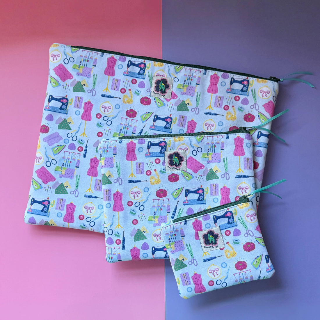 Small, medium and large sewing-print zip pouches with colourful sewing machines, scissors, dressmaking mannequins, embroidery hoops, unpickers and other sewing notions. Fabric is bright and colourful with a light blue background. 