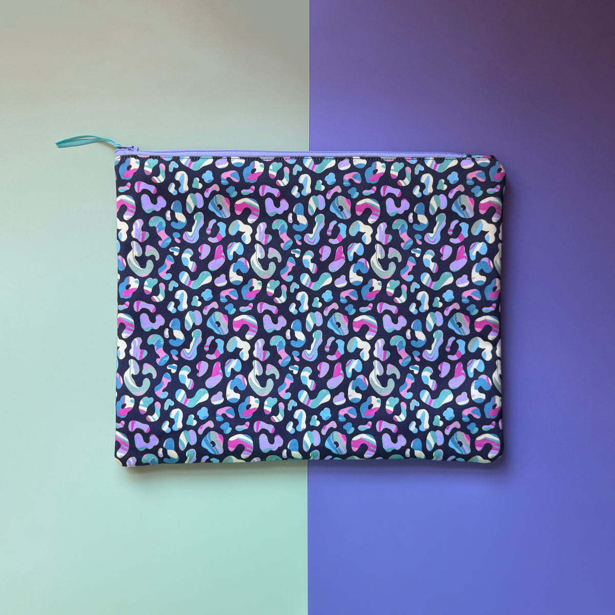 Back of the large leopard-print pouch, showing its all over colourful pattern and lilac zip. 