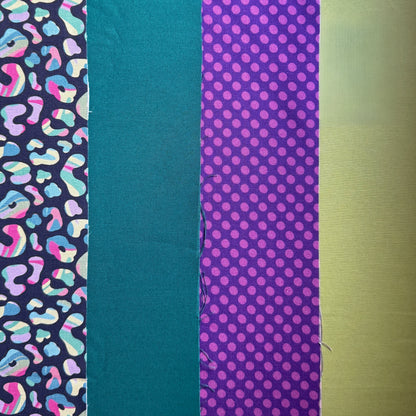 Four fabrics laid side by side: colourful leopard spots on navy, plain teal, purple polka dots and lime green.