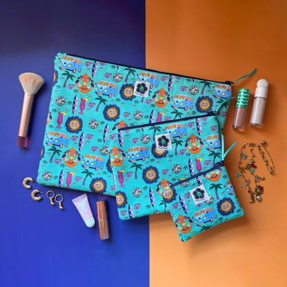 Small, medium and large turquoise Hippie Pouches arranged with cosmetics, a makeup brush and gold jewellery.