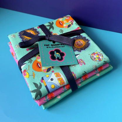 Hippie fat quarter bundle tied with a navy ribbon and turquoise ByLouMoffat tag, with the retro campervan print on top.
