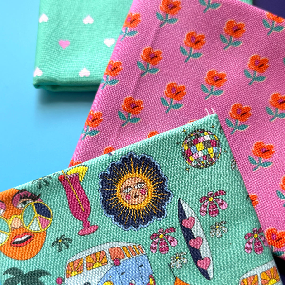Close-up of the hippie fat quarter bundle, showing the fabric texture, retro motifs, orange flowers and tiny hearts.