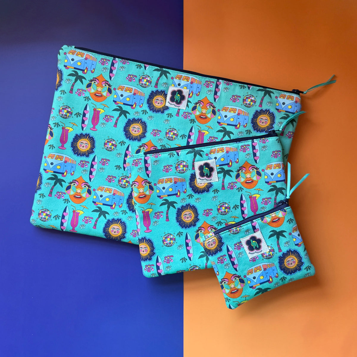 Three turquoise Hippie Pouches in small, medium and large sizes with a navy zip and teal ribbon. The fabric a colourful retro design featuring camper vans, palm trees, suns, disco balls, surfboard and cocktail glasses.