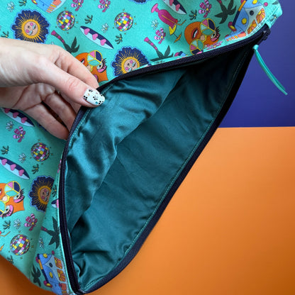 Hippie Pouch held open to show its plain dark green  lining, navy zip and turquoise printed outer fabric.