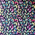 Leopard print fabric laid flat, showing multicoloured spots with striped and swirled details on a dark navy background.
