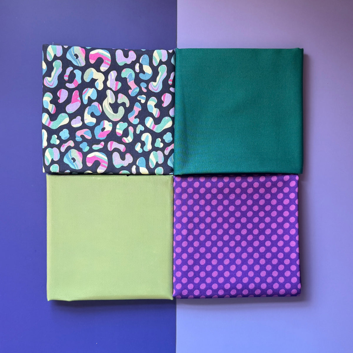 Four folded fat quarters arranged in a square, featuring colourful leopard print, plain teal, lime green and purple polka dots.