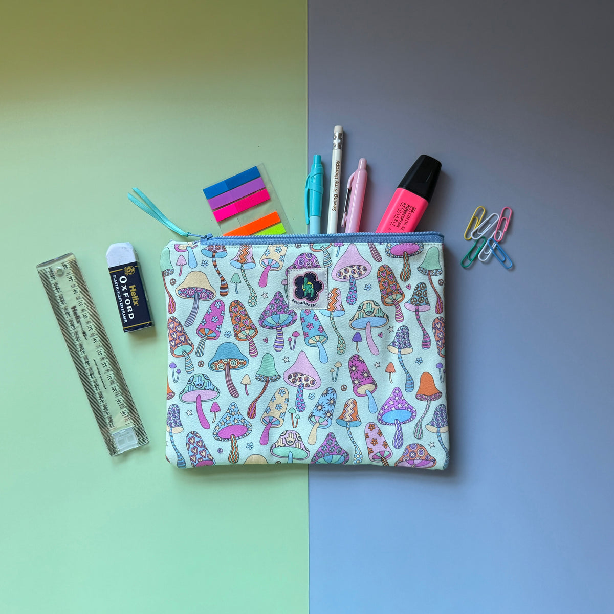 Medium mushroom-print zip pouch shown with pens, a pencil, highlighter, ruler and paper clips.