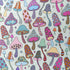 Colourful mushroom fabric laid flat, with hearts, stars, flowers, stripes and peace signs decorating the mushrooms on a pale mint green background.