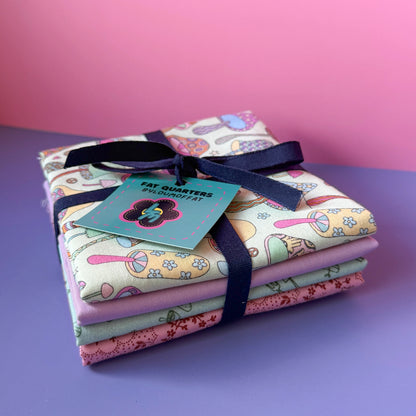 Mushroom fat quarter bundle stacked and tied with navy ribbon, finished with a turquoise ByLouMoffat tag.