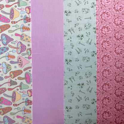 Four fabrics laid side by side: colourful mushroom print, plain lilac, sage green gardening print and pink floral print.