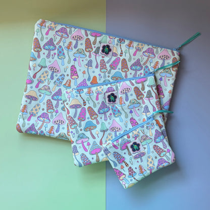 Three mushroom print zip pouches in small, medium and large, with colourful patterned mushrooms featuring stars, hearts, flowers hamsa hands and ByLouMoffat labels.