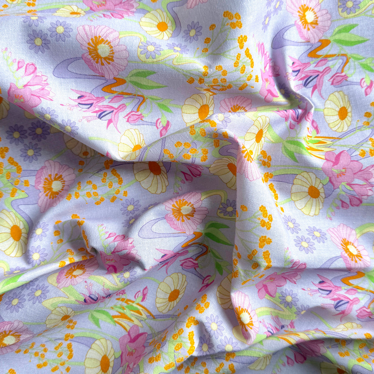 Draped Retro Bloom floral fabric showing its texture, pastel flowers and winding green stems on pale lilac.