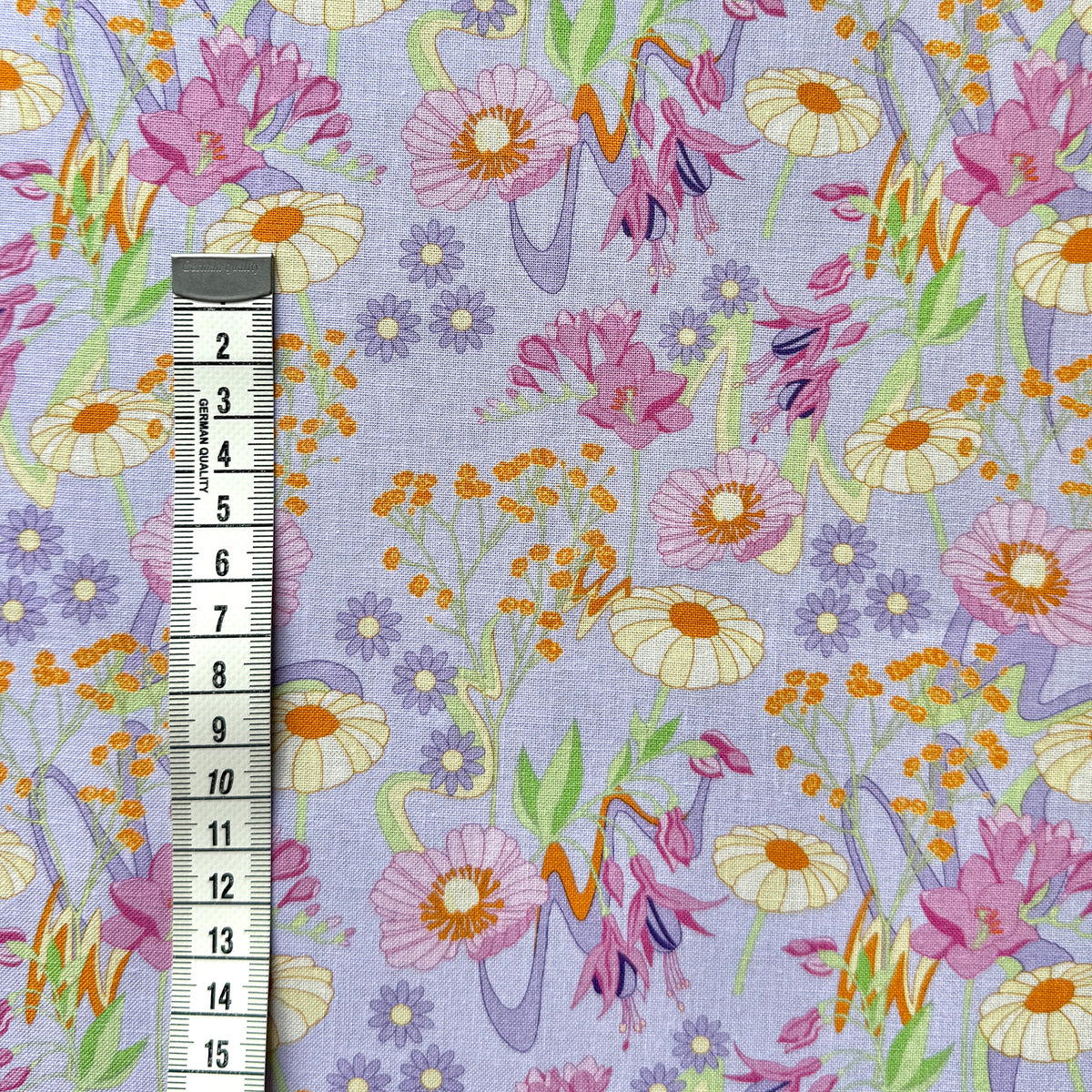 Retro Bloom floral fabric beside a centimetre tape measure to show the scale of the flower pattern.