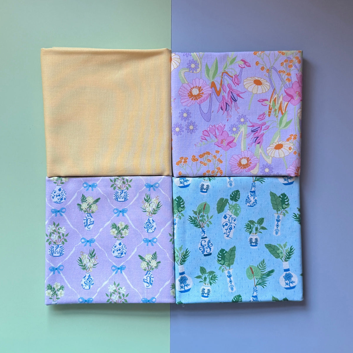 Four folded fat quarters arranged in a square, featuring plain yellow, retro florals and two potted plant prints.
