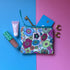 Small 60s floral zip pouch with a ByLouMoffat label, shown with cosmetics, a key, card and earrings.