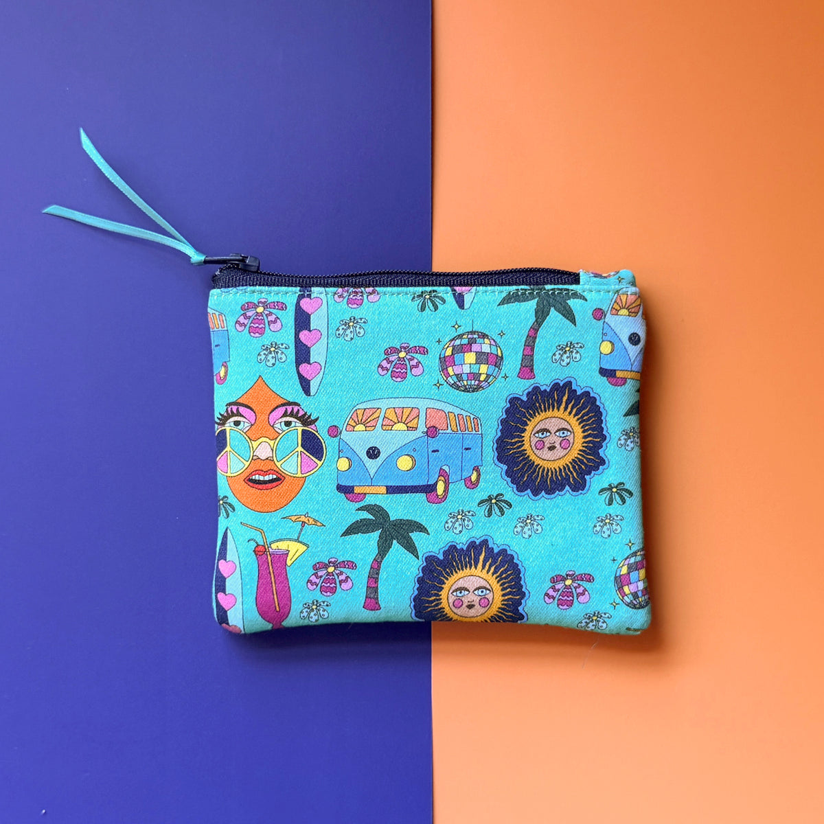 Back of the small turquoise Hippie Pouch, showing campervans, palm trees, disco balls and illustrated faces with a navy zip and tea ribbon pull. .