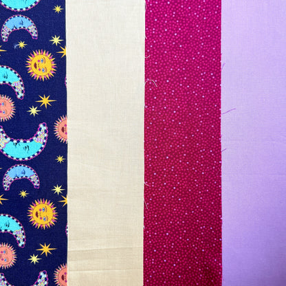 Close-up of the Sun and Moon fat quarter bundle, showing colourful celestial motifs and coordinating lilac, berry pink and yellow fabrics.
