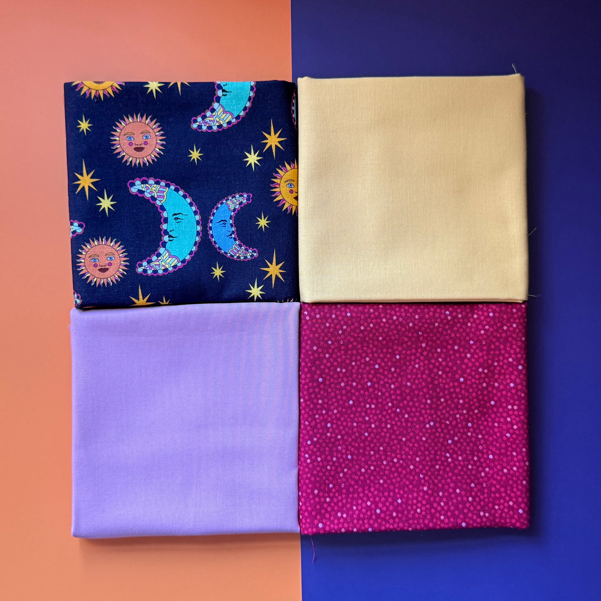 Four folded fat quarters arranged in a square, featuring a navy celestial print, pale yellow, lilac and berry pink fabrics.