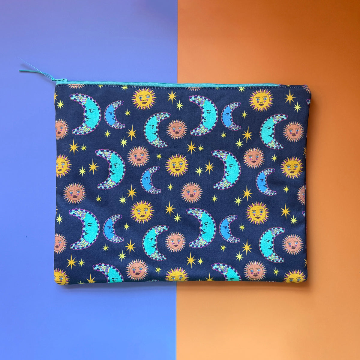 Back of the large navy sun and moon print pouch with a turquoise zip and matching ribbon pull.